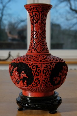 Bauchvase rot/schwarz mit Untersetzer. Wohl China, florale Reliefverzierung.