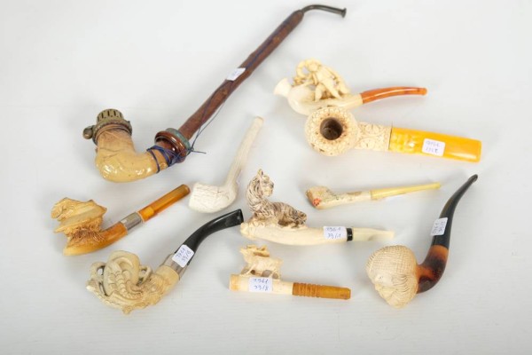 KONVOLUT AUS GESCHNITZTEN MEERSCHAUMPFEIFEN, 10 Meerschaumpfeifen. Meerschaumpfeife mit Tiger eingeschnitzt, L: 13cm. Meerschaumpfeife mit einem eingeschnitzten Männerkopf mit Turban, L:16cm. Meerschaumpfeife aus Japan, handgeschnitzte Ankerverzierungen, L: 11.5cm. Meerschaumpfeife Frauenkopf mit Hut, leichte beschädigte Stellen, L: 12cm. Holzpfeife mit Meerschaumkopf, 1761, eingeschnitzter Musiker, L: 30cm.  Meerschaumpfeife mit eingeschnitztem Jäger, L: 13.5cm. Deko Meerschaumpfeife mit ein