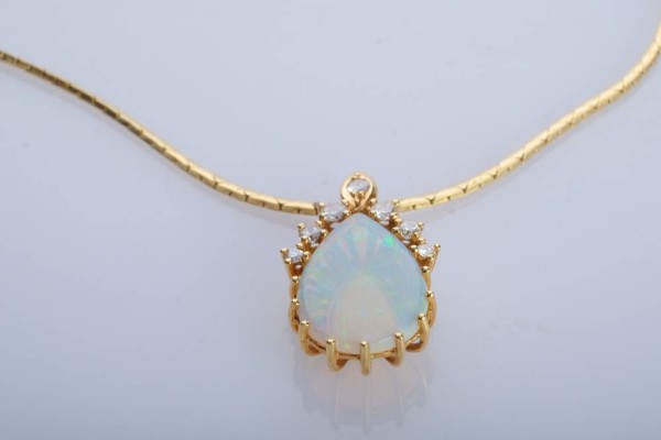 OPAL-ANHÄNGER in Tropfenform, flankiert von sieben Brillanten, gesamt um 0,3ct, Opal 1,5x1cm in Krappen gefasst, wunderbare Brillanz, schimmernd in Grün/Blau/Rot, an SCHLANGEN-KETTE, L 41cm, Gelbgold 750 (punziert), Steckverschluss mit Sicherheitsacht, Kette 6,76g, Opal-Anhänger 2,65g *ein ganz besonderes Stück