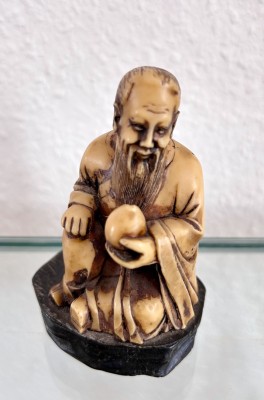 Netsuke, sitzender bärtiger Mann.